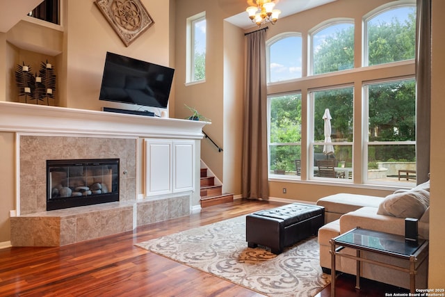 living room with stairs, baseboards, wood finished floors, and a fireplace