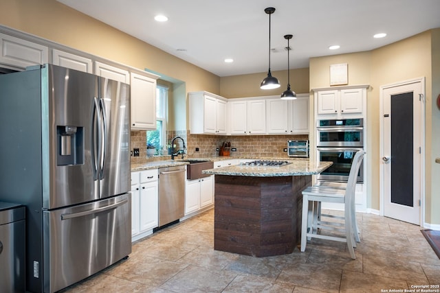 kitchen featuring a sink, decorative backsplash, stainless steel appliances, and white cabinets
