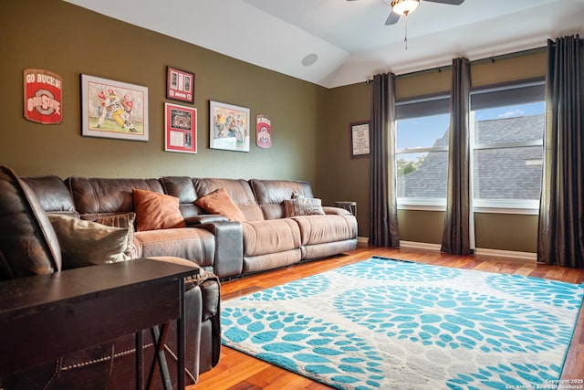 living area featuring ceiling fan, vaulted ceiling, baseboards, and light wood-type flooring