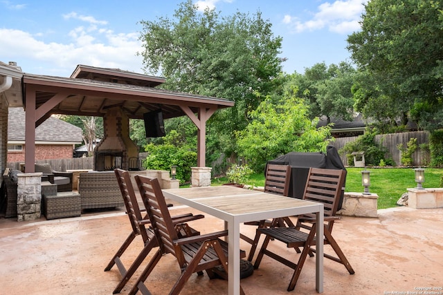 view of patio featuring a gazebo, outdoor dining area, a fenced backyard, and an outdoor living space with a fireplace