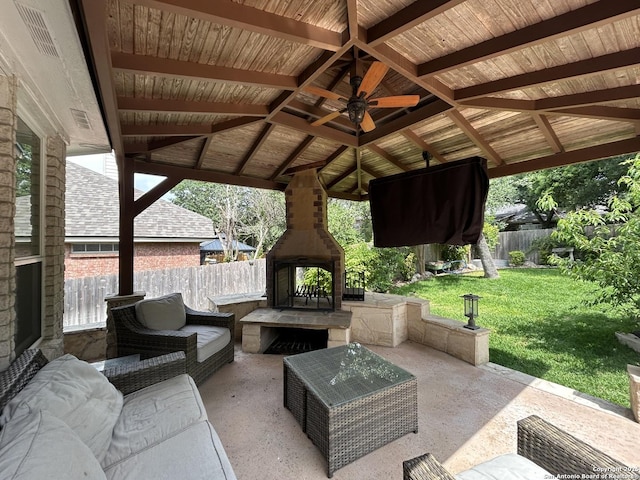 view of patio featuring a fenced backyard, a ceiling fan, an outdoor living space with a fireplace, and a gazebo