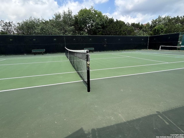 view of tennis court featuring fence