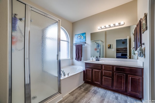 9110 Feather Blf, Helotes, TX 78023 - bathroom with wood finished floors, a shower stall, a bath, and vanity