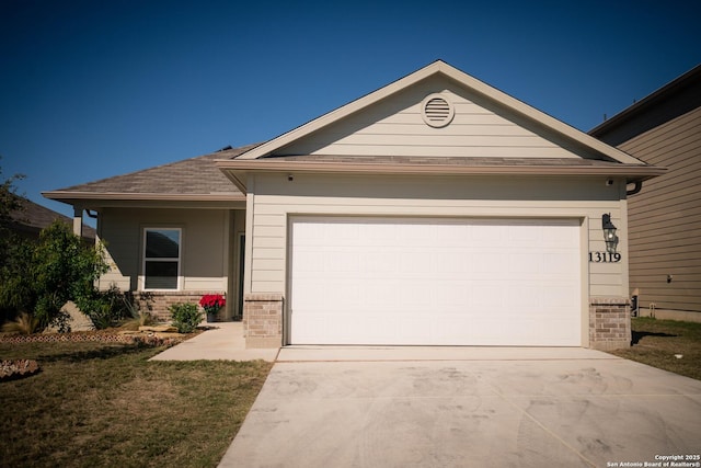 ranch-style home with brick siding, an attached garage, a front yard, and concrete driveway