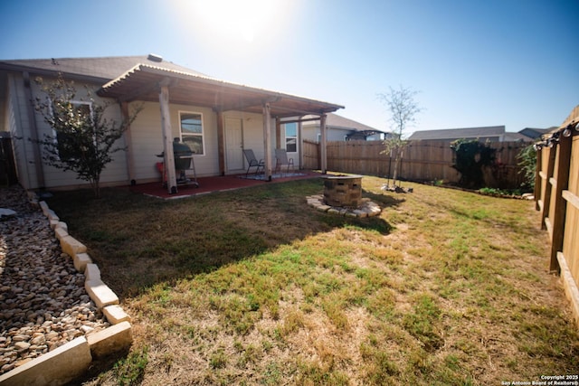 view of yard featuring a fenced backyard, a fire pit, and a patio area
