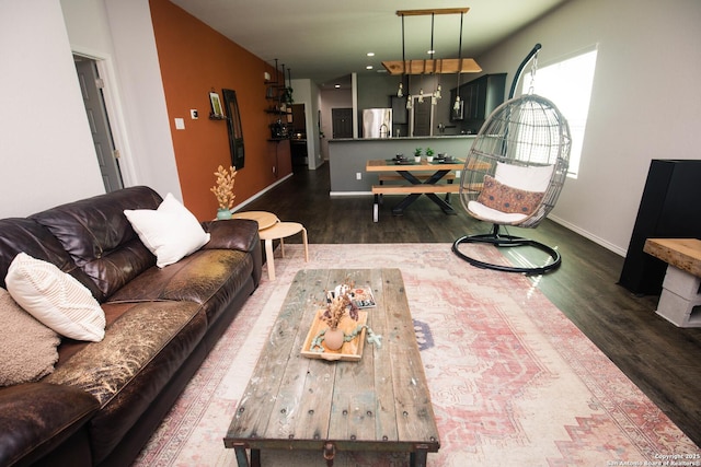 living area with baseboards and wood finished floors
