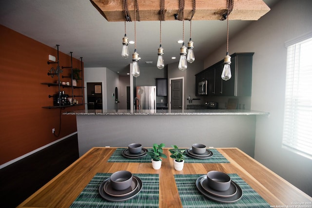 dining area with baseboards and wood finished floors