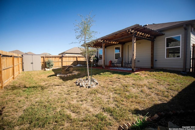 view of yard featuring an outdoor structure, a fenced backyard, a shed, a patio, and a pergola