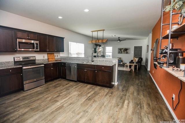kitchen with a peninsula, dark brown cabinetry, a ceiling fan, dark wood finished floors, and appliances with stainless steel finishes