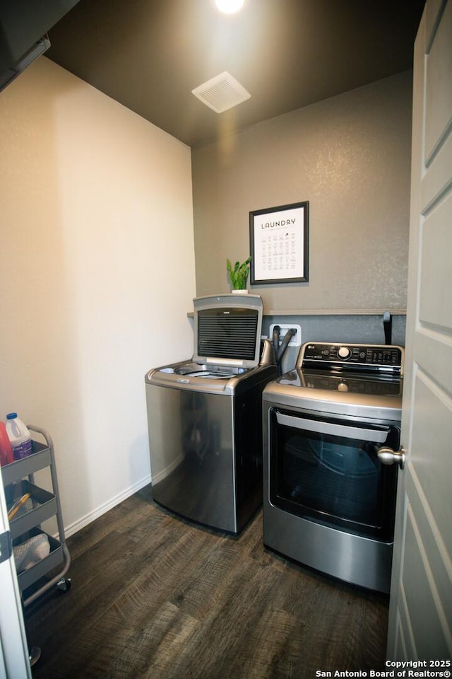 washroom featuring washer and dryer, dark wood-style flooring, laundry area, and baseboards