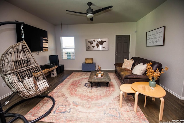 living area with baseboards, ceiling fan, and wood finished floors
