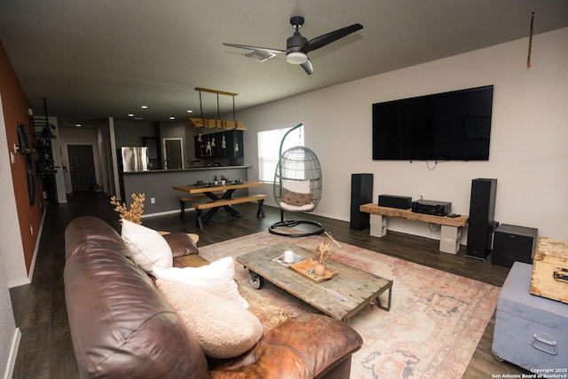 living room featuring a ceiling fan, baseboards, and wood finished floors