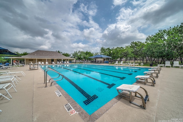community pool with fence and a patio area