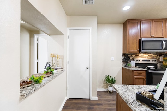 10022 Carswell Peak, San Antonio, TX 78245 - kitchen with decorative backsplash, baseboards, dark wood-type flooring, brown cabinets, and stainless steel appliances