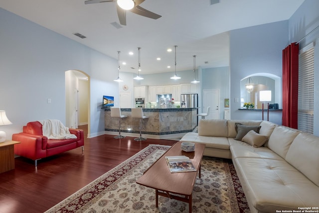 living area featuring ceiling fan, visible vents, arched walkways, dark wood finished floors, and recessed lighting
