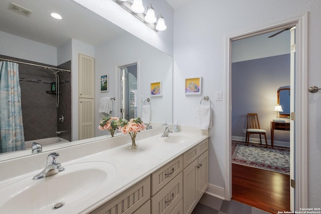 full bath featuring visible vents, a sink, shower / bath combo with shower curtain, and double vanity