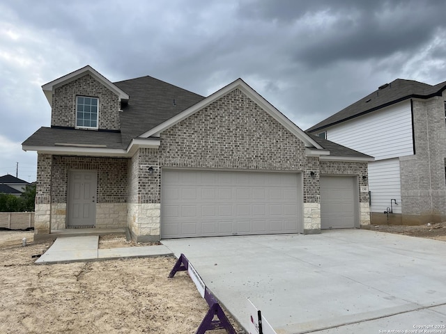 150 Hunters Cp, San Antonio, TX 78245 - traditional-style house with a shingled roof, an attached garage, stone siding, brick siding, and driveway