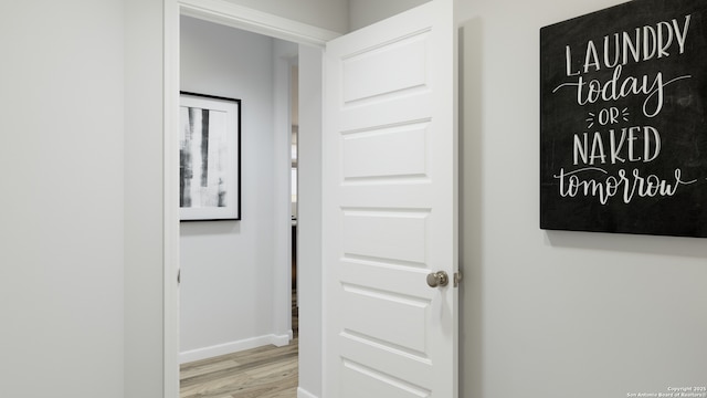 hall with baseboards and wood finished floors