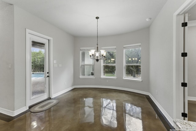 unfurnished dining area with baseboards, finished concrete floors, and a chandelier