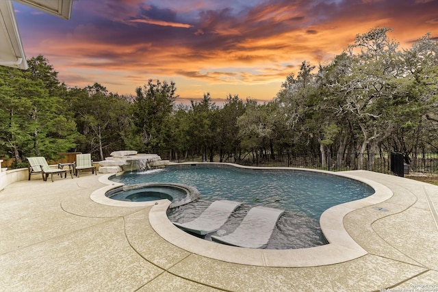 view of swimming pool with fence, an in ground hot tub, a fenced in pool, and a patio area