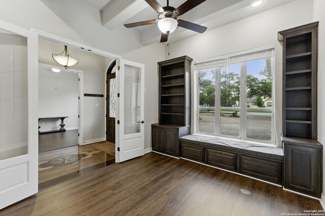 interior space featuring dark wood-type flooring, a ceiling fan, and baseboards