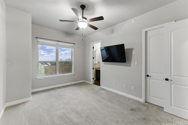unfurnished living room featuring carpet flooring, a ceiling fan, and baseboards