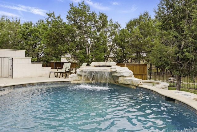 view of swimming pool with a hot tub, fence, a fenced in pool, and a patio