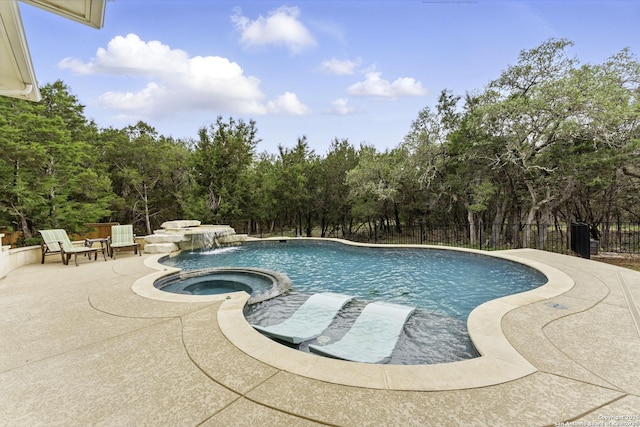 view of pool with a patio, fence, and a pool with connected hot tub
