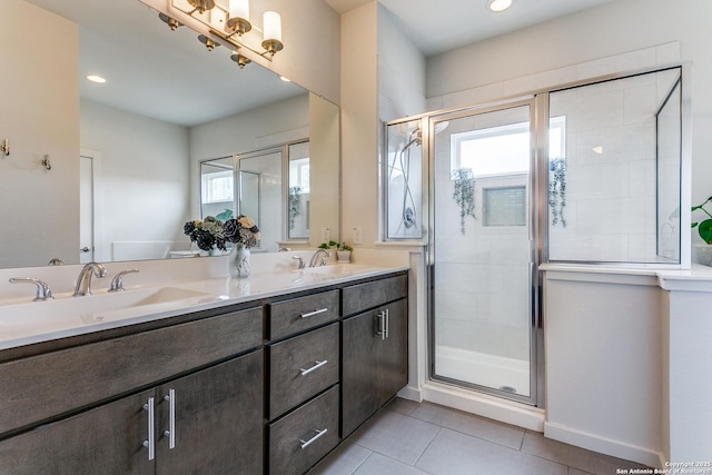 bathroom with double vanity, a sink, a stall shower, and tile patterned floors