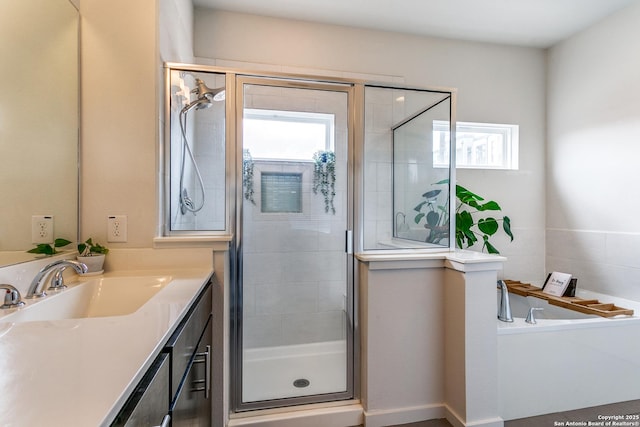 bathroom with a healthy amount of sunlight, vanity, a stall shower, and a bath