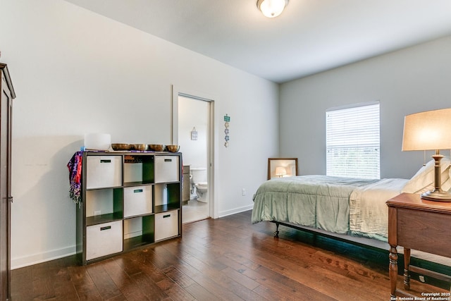 bedroom with baseboards, connected bathroom, and dark wood-style flooring