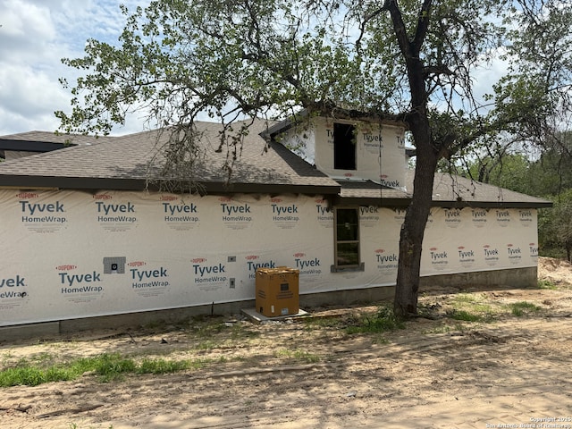 view of property exterior with a shingled roof