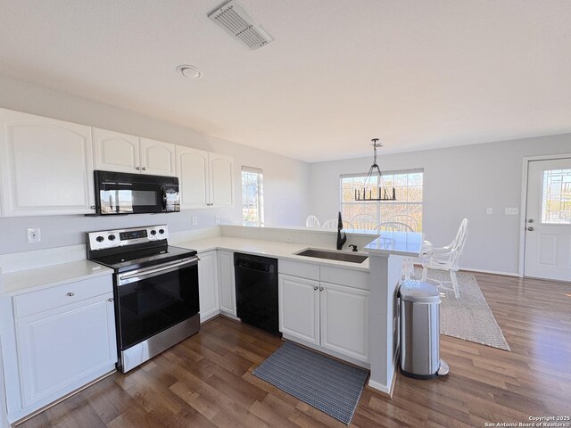 726 Barbara Dr, Canyon Lake, TX 78133 - kitchen with visible vents, a sink, dark wood-style flooring, and black appliances
