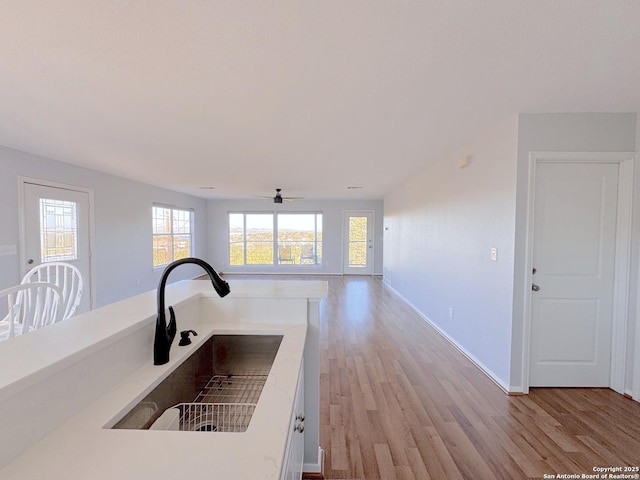 726 Barbara Dr, Canyon Lake, TX 78133 - details with a ceiling fan, baseboards, a sink, and light wood-style flooring