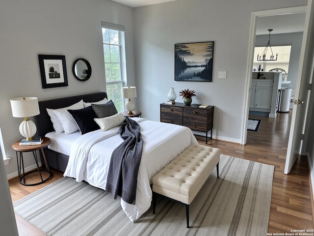 726 Barbara Dr, Canyon Lake, TX 78133 - bedroom featuring baseboards, a chandelier, and wood finished floors