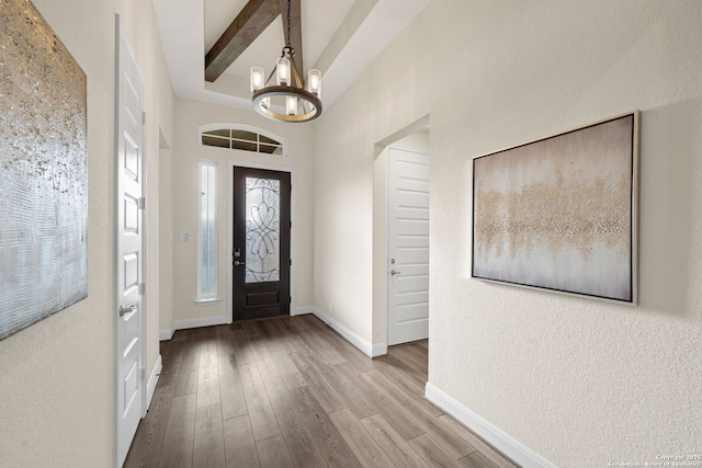 entrance foyer featuring baseboards, wood finished floors, and a chandelier