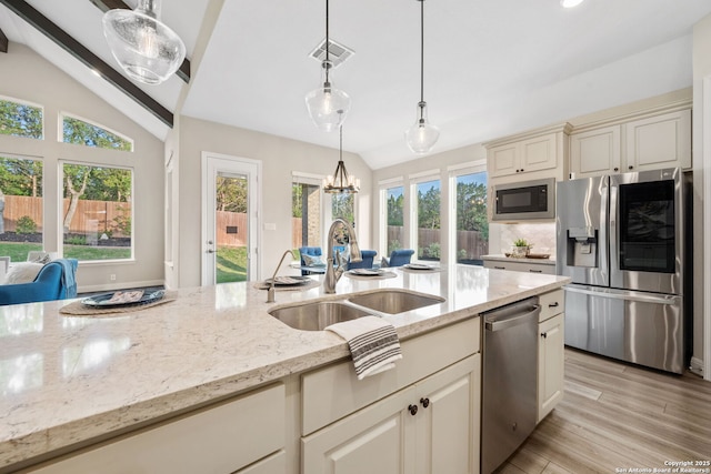 kitchen featuring a sink, appliances with stainless steel finishes, vaulted ceiling, and visible vents