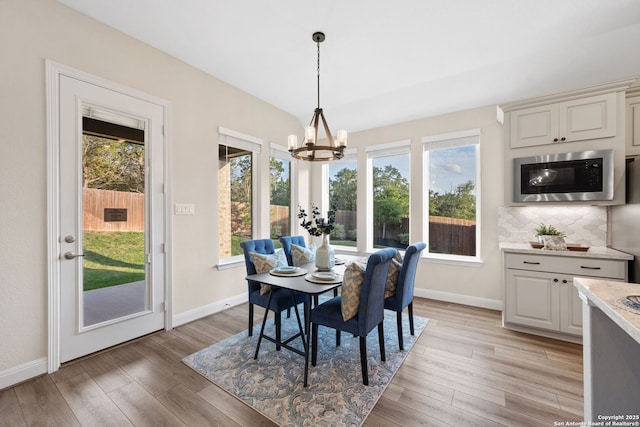 dining room featuring baseboards, a notable chandelier, and a healthy amount of sunlight