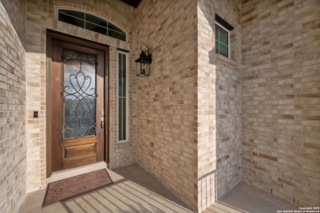 view of exterior entry with brick siding