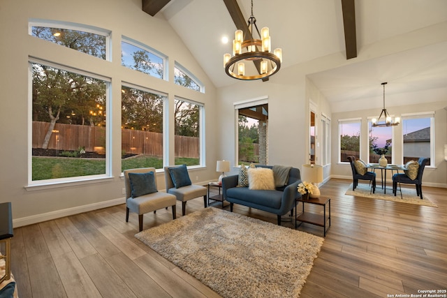 living area with high vaulted ceiling, baseboards, beamed ceiling, a chandelier, and hardwood / wood-style floors