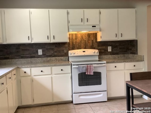 kitchen featuring backsplash, under cabinet range hood, light tile patterned flooring, and electric stove