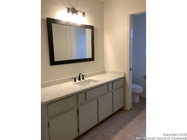bathroom with tile patterned flooring, toilet, and vanity