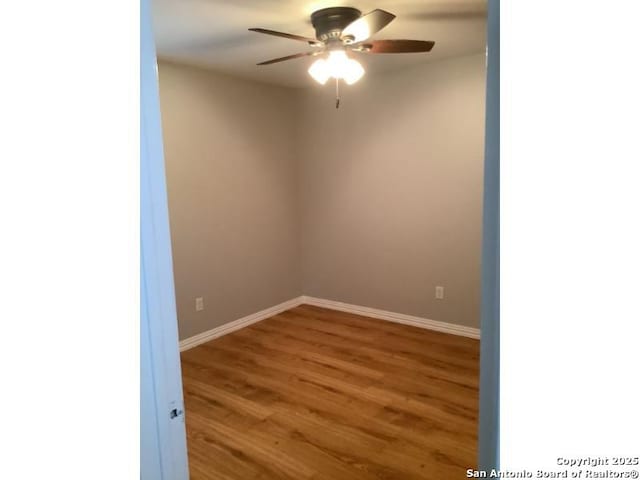 empty room featuring baseboards, ceiling fan, and wood finished floors