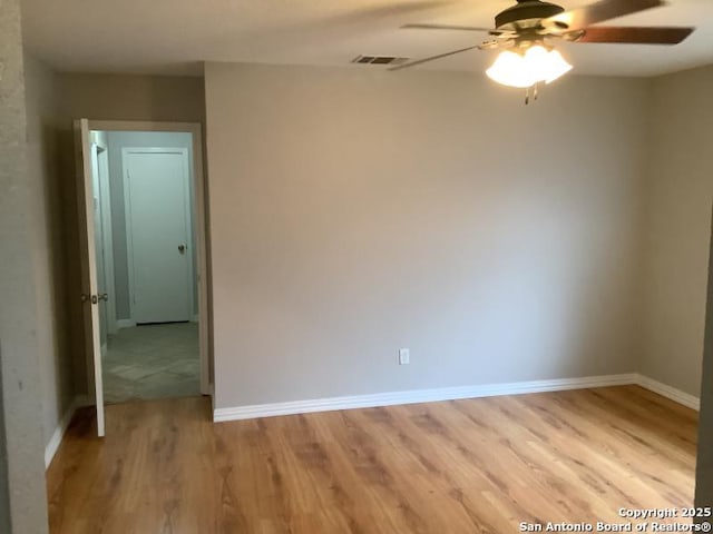 spare room with a ceiling fan, baseboards, visible vents, and light wood-style flooring