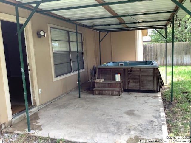 view of patio / terrace featuring fence and a hot tub