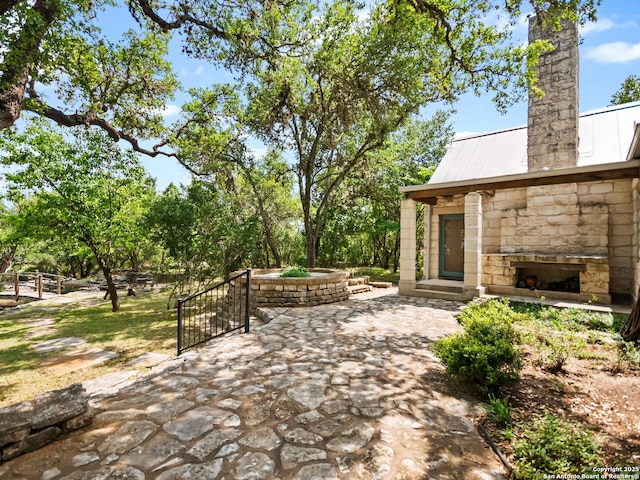 view of patio featuring an outdoor stone fireplace
