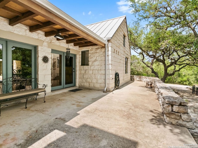 exterior space featuring a standing seam roof, a patio area, and metal roof