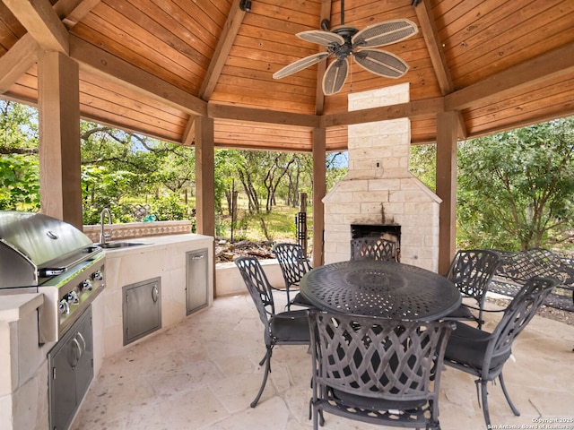 view of patio featuring ceiling fan, outdoor dining area, an outdoor kitchen, area for grilling, and a gazebo