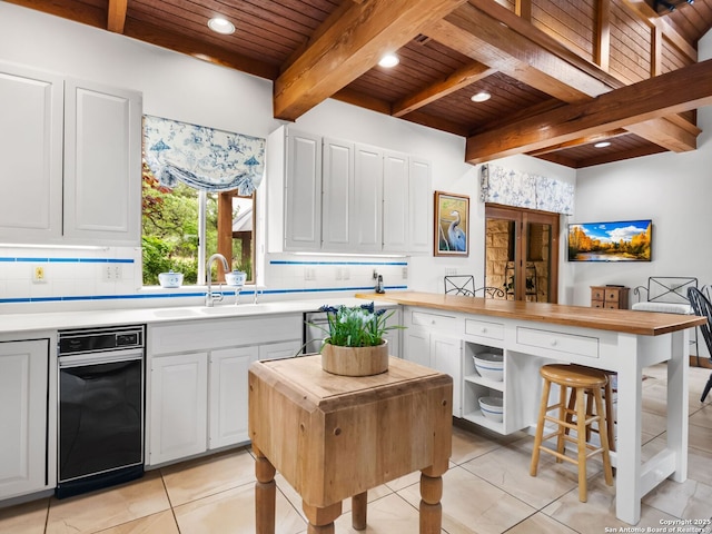 kitchen featuring a sink, decorative backsplash, wooden ceiling, and beamed ceiling