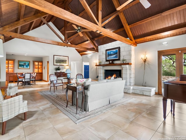 living room with wood ceiling, ceiling fan, a stone fireplace, beam ceiling, and high vaulted ceiling